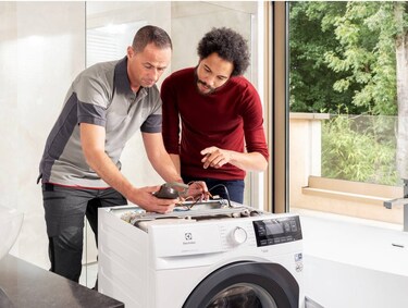 technician repairing an electrolux washing machine